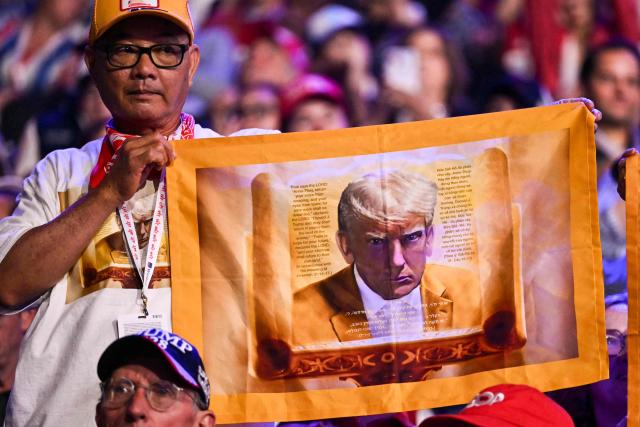 An attendee holds an image of US President Donald Trump during the Republican National Midterm Convention at the American Airlines Center in Dallas, Texas on September 9, 2026. US Republicans open an extraordinary midterm convention in Dallas on September 9 betting that putting Donald Trump at the center of their campaign can rescue a party facing grim election forecasts -- despite the president's negative approval ratings. (Photo by Kent NISHIMURA / AFP)