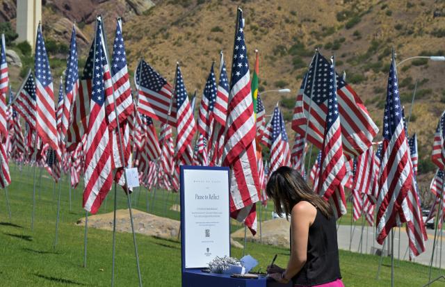 A visitor writes a message for publication on the organization's website as US flags are displayed at Pepperdine University in Malibu, California, on September 9, 2026, as part of the annual Wave of Flags commemorating the September 11, 2001 attacks. (Photo by Frederic J. BROWN / AFP)