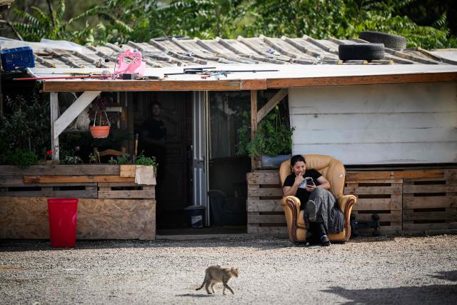 (FILES) A member of the Roma community sits in the "La Prairie des Mauves" settlement in Nantes, western France, on August 31, 2026. Between 700 and 1,000 people, mostly Roma, live in the few "hamlets" of the Prairie de Mauves, to the east of Nantes – a haphazard collection of caravans and small houses made of mismatched planks, where pieces of wood and abandoned furniture are piled up in a jumble. Not far from the tracks of the Nantes–Angers line, the shacks in the Moulin des Marees shantytown have been partly dismantled, the site littered with pieces of wood and overturned furniture. The evictions have been criticised both by the local right wing parties, which condemns a "piecemeal" approach, and by the Nantes branch of the French left-wing party La France Insoumise, which deplores what it calls organised "wandering". (Photo by Loic VENANCE / AFP)