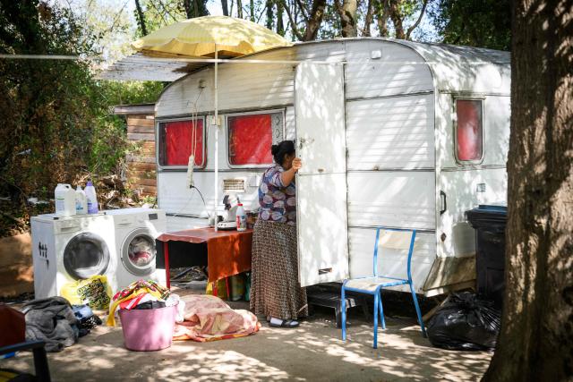 (FILES) A member of the Roma community peers into a caravan in a new settlement after being evacuated two weeks earlier from the "le moulin des marais" Roma community settlement in Nantes, western France, on August 31, 2026. Between 700 and 1,000 people, mostly Roma, live in the few "hamlets" of the Prairie de Mauves, to the east of Nantes – a haphazard collection of caravans and small houses made of mismatched planks, where pieces of wood and abandoned furniture are piled up in a jumble. Not far from the tracks of the Nantes–Angers line, the shacks in the Moulin des Marees shantytown have been partly dismantled, the site littered with pieces of wood and overturned furniture. The evictions have been criticised both by the local right wing parties, which condemns a "piecemeal" approach, and by the Nantes branch of the French left-wing party La France Insoumise, which deplores what it calls organised "wandering". (Photo by Loic VENANCE / AFP)