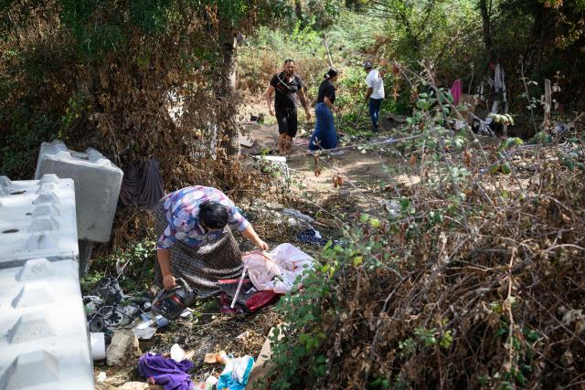 (FILES) Members of the Roma community clear an area to establish a new settlement, two weeks after being evacuated from the "le moulin des marais" Roma community settlement in Nantes, western France, on August 31, 2026. Between 700 and 1,000 people, mostly Roma, live in the few "hamlets" of the Prairie de Mauves, to the east of Nantes – a haphazard collection of caravans and small houses made of mismatched planks, where pieces of wood and abandoned furniture are piled up in a jumble. Not far from the tracks of the Nantes–Angers line, the shacks in the Moulin des Marees shantytown have been partly dismantled, the site littered with pieces of wood and overturned furniture. The evictions have been criticised both by the local right wing parties, which condemns a "piecemeal" approach, and by the Nantes branch of the French left-wing party La France Insoumise, which deplores what it calls organised "wandering". (Photo by Loic VENANCE / AFP)