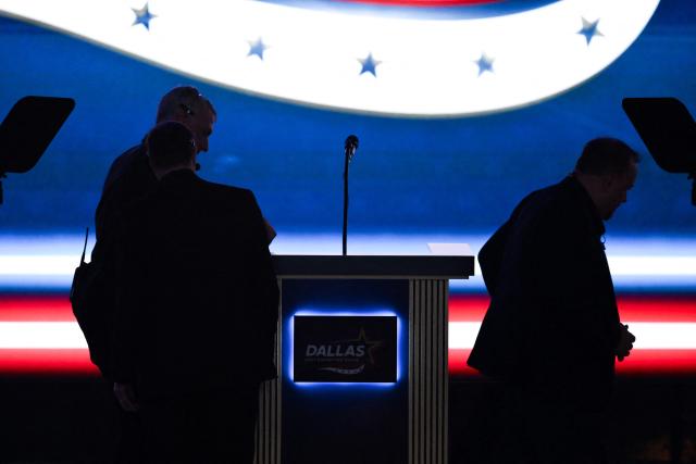 Crew members fix the podium after a letter L fell off in "Dallas" during the Republican National Midterm Convention at the American Airlines Center in Dallas, Texas on September 9, 2026. US Republicans open an extraordinary midterm convention in Dallas on September 9 betting that putting Donald Trump at the center of their campaign can rescue a party facing grim election forecasts -- despite the president's negative approval ratings. (Photo by Patrick T. Fallon / AFP)