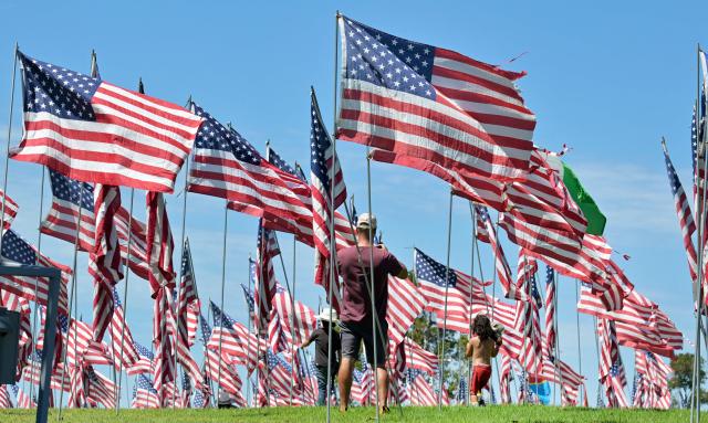 Visitors walk through US flags displayed at Pepperdine University in Malibu, California, on September 9, 2026, as part of the annual Wave of Flags commemorating the September 11, 2001 attacks. (Photo by Frederic J. BROWN / AFP)