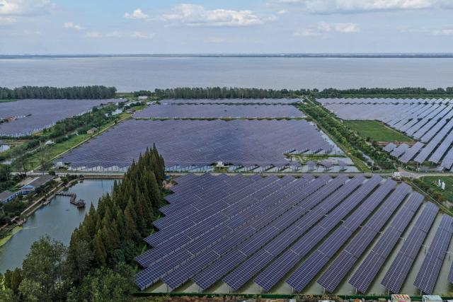 Solar panels are seen above ponds in Yangzhou, in China’s eastern Jiangsu province on September 9, 2026. (Photo by CN-STR / AFP) / China OUT