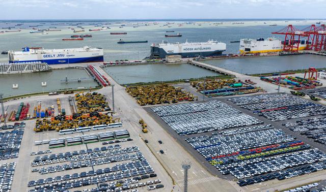 Three specialized car transport ships are seen behind rows of cars waiting to be loaded at Suzhou port, in China’s eastern Jiangsu province on September 9, 2026. (Photo by CN-STR / AFP) / China OUT
