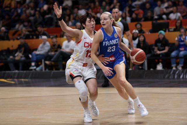 France's shooting guard #23 Marine Johannes (R) and China's shooting guard #12 Chen Yujie vie for the ball during the 2026 FIBA Women's Basketball World Cup quarter-final match between China and France at the Berlin Arena in Berlin on September 10, 2026. (Photo by Ronny HARTMANN / AFP)