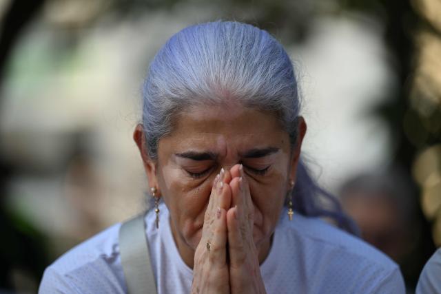 A relative of the victims of the 7.4- magnitude earthquake prays during a ceremony in honor of the victims one month after the tragedy at Maria Inmaculada Church, near Torres del Limonar, in Cali, Colombia on September 10, 2026. (Photo by JOAQUIN SARMIENTO / AFP)