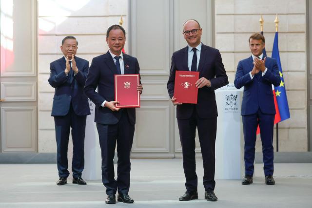French Minister Delegate for Industry Sebastien Martin (2nd R) and Vietnamese Academy of Science and Technology President Tran Hong Thai (2nd L) pose flanked by French President Emmanuel Macron (R) and Vietnamese General Secretary and President To Lam (L) during a signing ceremony at the Elysee Palace in Paris on September 10, 2026. (Photo by Yoan VALAT / POOL / AFP)