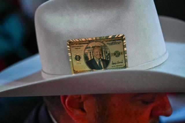 An attendee from Texas wears decorative Trump-themed faux currency on his hat during the second day of the Republican National Committee midterm convention at the American Airlines Center in Dallas, Texas on September 10, 2026. US Republicans are betting that putting President Donald Trump at the center of their campaign can rescue a party facing grim election forecasts, despite the president's negative approval ratings. A day earlier, on the first day of the midterm convention, he promised $5,000 to every American adult if Republicans retain control of Congress in November. (Photo by Kent NISHIMURA / AFP)