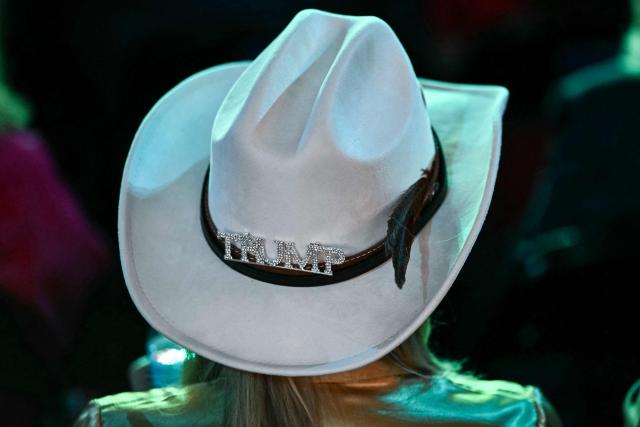 An attendee from Texas wears a "TRUMP" broach on her hat during the second day of the Republican National Committee midterm convention at the American Airlines Center in Dallas, Texas on September 10, 2026. US Republicans are betting that putting President Donald Trump at the center of their campaign can rescue a party facing grim election forecasts, despite the president's negative approval ratings. A day earlier, on the first day of the midterm convention, he promised $5,000 to every American adult if Republicans retain control of Congress in November. (Photo by Kent NISHIMURA / AFP)