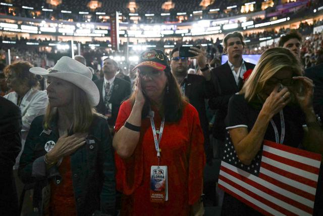 Attendees react as a video about the 9/11 attacks is played during the second day of the Republican National Committee midterm convention at the American Airlines Center in Dallas, Texas on September 10, 2026. US Republicans are betting that putting President Donald Trump at the center of their campaign can rescue a party facing grim election forecasts, despite the president's negative approval ratings. A day earlier, on the first day of the midterm convention, he promised $5,000 to every American adult if Republicans retain control of Congress in November. (Photo by RONALDO SCHEMIDT / AFP)