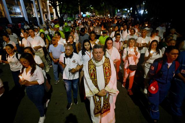 Relatives of the victims of the 7.4-magnitude earthquake light candles as they take part in a vigil in honor of the victims one month after the tragedy in Cali, Colombia, on September 10, 2026. (Photo by Joaquin SARMIENTO / AFP)