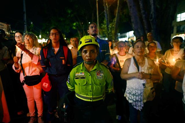 Relatives of the victims of the 7.4-magnitude earthquake light candles as they take part in a vigil in honor of the victims one month after the tragedy in Cali, Colombia, on September 10, 2026. (Photo by Joaquin SARMIENTO / AFP)