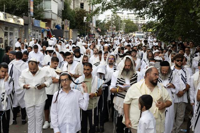 Hasidic Jewish pilgrims pray along a street near the tomb of Rabbi Nachman ahead of the Jewish New Year, Rosh Hashanah, in Uman, central Ukraine, on September 12, 2026, amid the Russian invasion of Ukraine. Tens of thousands of Jewish pilgrims flock to the Ukrainian city of Uman despite the war for their annual pilgrimage to the tomb of Rabbi Nachman of Breslov (1772–1810), founder of the Breslov Hasidic movement, which established a community in Uman in the early 19th century. (Photo by Serhii Okunev / AFP)