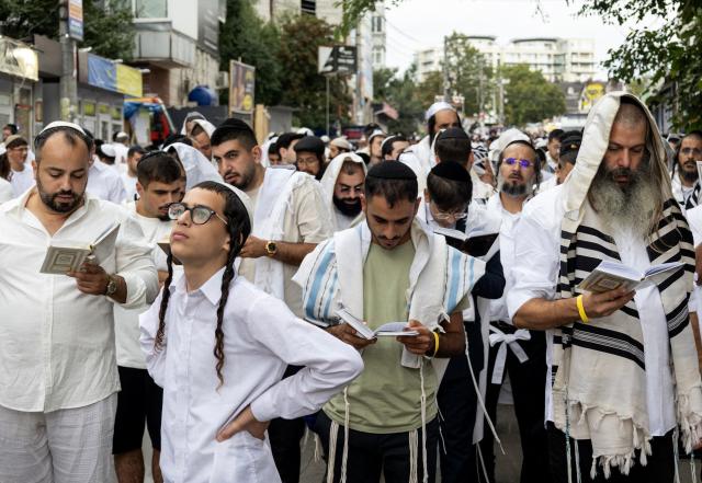 Hasidic Jewish pilgrims pray along a street near the tomb of Rabbi Nachman ahead of the Jewish New Year, Rosh Hashanah, in Uman, central Ukraine, on September 12, 2026, amid the Russian invasion of Ukraine. Tens of thousands of Jewish pilgrims flock to the Ukrainian city of Uman despite the war for their annual pilgrimage to the tomb of Rabbi Nachman of Breslov (1772–1810), founder of the Breslov Hasidic movement, which established a community in Uman in the early 19th century. (Photo by Serhii Okunev / AFP)