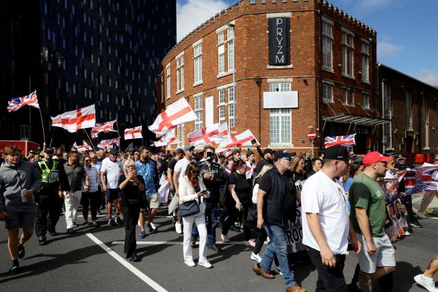 People take part in an anti-immigration demonstration and march in the streets in the city of Portsmouth, southern England on September 12, 2026. Protesters at planned anti-immigration and counter-demonstration rallies in southern England were expected to be banned from wearing face masks, police said on September 11, amid fears of unrest. (Photo by Brook Mitchell / AFP)