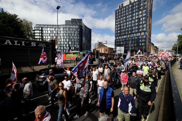 People take part in an anti-immigration demonstration and march in the streets in the city of Portsmouth, southern England on September 12, 2026. Protesters at planned anti-immigration and counter-demonstration rallies in southern England were expected to be banned from wearing face masks, police said on September 11, amid fears of unrest. (Photo by Brook Mitchell / AFP)