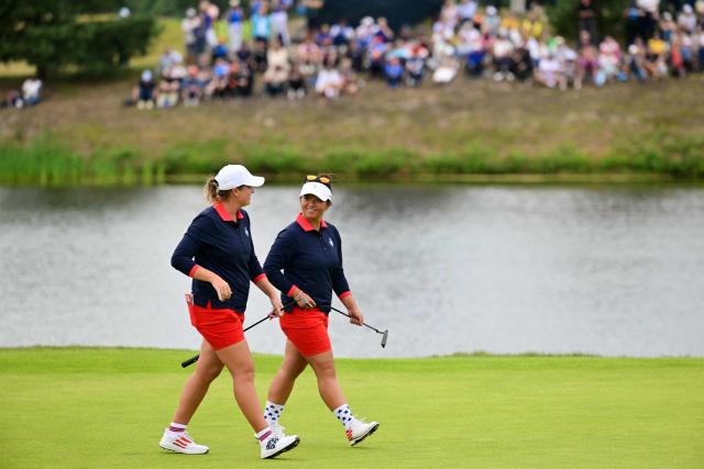 US teams golfer Megan Khang (R) walks with partner US teams golfer Lauren Coughlin during play in their fourball match against Team Europe players on the second day of the 2026 Solheim Cup biennial team golf competition on The Bernardus Golf Course at Cromvoirt, some 80kms south-east of Rotterdam on September 12, 2026. (Photo by NICOLAS TUCAT / AFP)