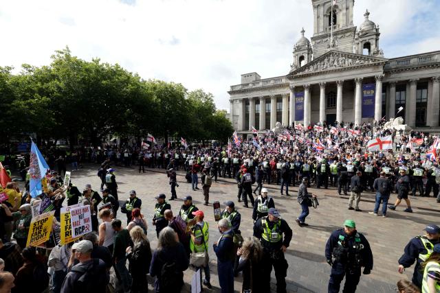 People taking part in an anti-immigration demonstration and march (R) square off with anti-far right demonstrators (L) in the city of Portsmouth, southern England on September 12, 2026. Protesters at planned anti-immigration and counter-demonstration rallies in southern England were expected to be banned from wearing face masks, police said on September 11, amid fears of unrest. (Photo by Brook Mitchell / AFP)