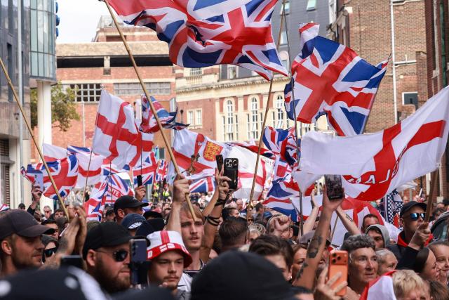 EDITORS NOTE: Graphic content / People take part in an anti-immigration demonstration and march in the city of Portsmouth, southern England on September 12, 2026. Protesters at planned anti-immigration and counter-demonstration rallies in southern England were expected to be banned from wearing face masks, police said on September 11, amid fears of unrest. (Photo by Brook Mitchell / AFP)