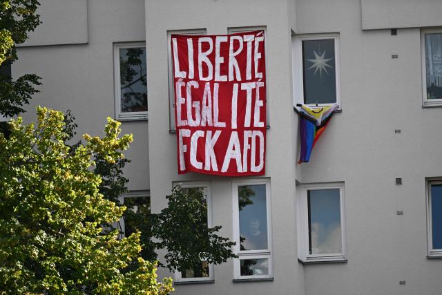 A banner reading "Liberte, egalite, Fck AFD" referring to far-right Alternative for Germany (AfD) party is fixed at a house during a final election campaign rally of far-right Alternative for Germany (AfD) party ahead of Berlin's state election on September 12, 2026. (Photo by RALF HIRSCHBERGER / AFP)