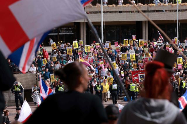 People taking part in an anti-immigration demonstration and march (front) look out at anti-far right demonstrators (behind) in the city of Portsmouth, southern England on September 12, 2026. Protesters at planned anti-immigration and counter-demonstration rallies in southern England were expected to be banned from wearing face masks, police said on September 11, amid fears of unrest. (Photo by Brook Mitchell / AFP)