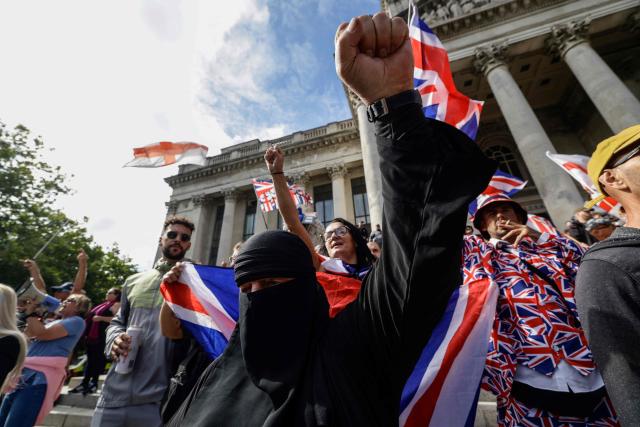 People take part in an anti-immigration demonstration and march in the city of Portsmouth, southern England on September 12, 2026. Protesters at planned anti-immigration and counter-demonstration rallies in southern England were expected to be banned from wearing face masks, police said on September 11, amid fears of unrest. (Photo by Brook Mitchell / AFP)