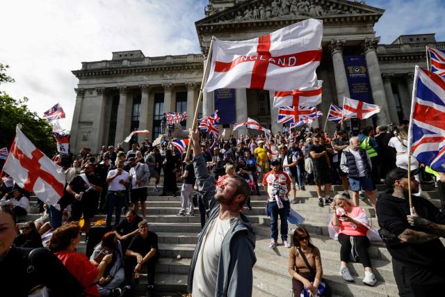 People take part in an anti-immigration demonstration and march in the city of Portsmouth, southern England on September 12, 2026. Protesters at planned anti-immigration and counter-demonstration rallies in southern England were expected to be banned from wearing face masks, police said on September 11, amid fears of unrest. (Photo by Brook Mitchell / AFP)
