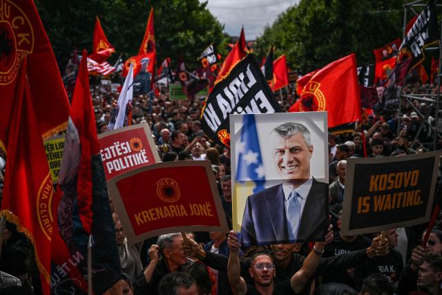 Kosovo Albanians holding placards and waving Kosovo Liberation Army (KLA) flags take part in the “March for Freedom” in Pristina on September 12, 2026, four days before the verdict in the war crimes trial of Hashim Thaci (seen on placard C) is due to be announced. Tens of thousand of participants gathered in Kosovo's capital on September 12, 2026 to demand the acquittal of former President Hashim Thaci, days ahead of a long-awaited war crimes verdict against the ex-guerrilla leader. (Photo by Armend NIMANI / AFP)