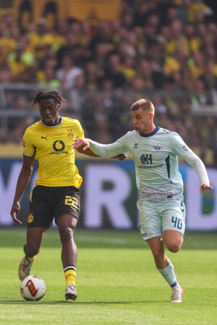 Dortmund's French defender #22 Joane Gadou and Paderborn's German-Croatian forward #40 Gabriel Vidovic vie for the ball during the German first division Bundesliga football match between Borussia Dortmund and SC Paderborn in Dortmund on September 12, 2026. (Photo by Leon Kuegeler / AFP) / DFL REGULATIONS PROHIBIT ANY USE OF PHOTOGRAPHS AS IMAGE SEQUENCES AND/OR QUASI-VIDEO