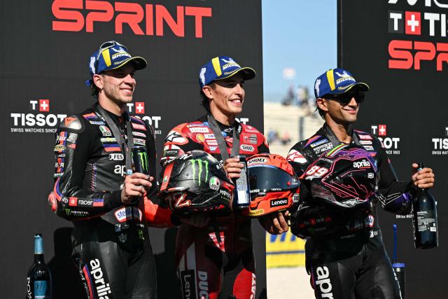 (FROM L) Second place Aprilia Racing's Italian rider Marco Bezzecchi, first place Ducati Lenovo Team's Spanish rider Marc Marquez and third place Aprilia Racing's Spanish rider Jorge Martin celebrate on the podium after the San Marino Moto GP Sprint Race at the Misano World Circuit Marco Simoncelli, in Misano Adriatico, northern Italy on September 12, 2026.  (Photo by Andreas SOLARO / AFP)