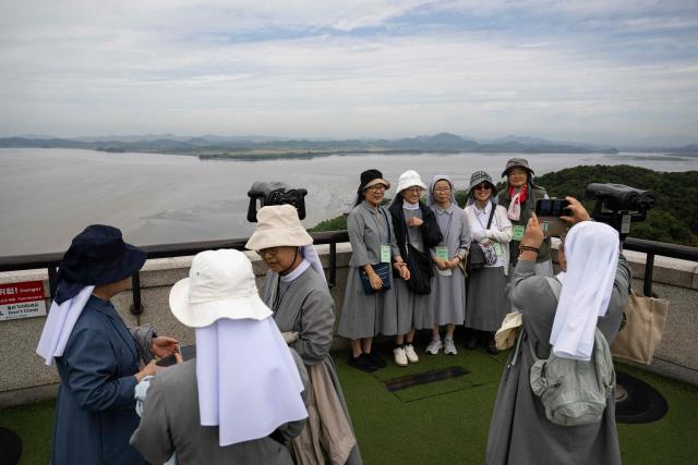 Visitors take pictures in front of the confluence of the Han River, Imjin River and North Korea from South Korea's Odusan Unification Observatory near the Demilitarized Zone (DMZ) dividing the two Koreas, in Paju on September 12, 2026. (Photo by Lillian SUWANRUMPHA / AFP)