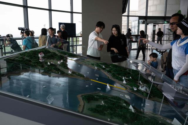 Visitors look at a map dividing North and South Korea in South Korea's Odusan Unification Observatory near the Demilitarized Zone (DMZ) dividing the two Koreas, in Paju on September 12, 2026. (Photo by Lillian SUWANRUMPHA / AFP)