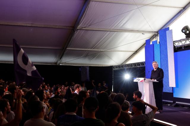 Supporters cheer as the image of French left-wing party La France Insoumise (LFI) founder and candidate in France’s 2027 presidential election Jean-Luc Melenchon is displayed on a screen prior to LFI speeches during the annual "Fete de l'Humanite" festival organised by French left wing newspaper L'Humanite, in Le Plessis-Pate, south of Paris, on September 12, 2026. (Photo by GEOFFROY VAN DER HASSELT / AFP)