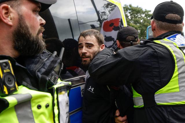 Police arrest an anti-immigration demonstrator (C) during a protest in the city of Portsmouth, southern England on September 12, 2026. Hundreds of anti-immigration protesters and counter-demonstrators faced off on September 12 in the southern English city of Portsmouth, at closely-watched duelling rallies which authorities fear could descend into unrest after violent scenes there on September 6. (Photo by Brook Mitchell / AFP)