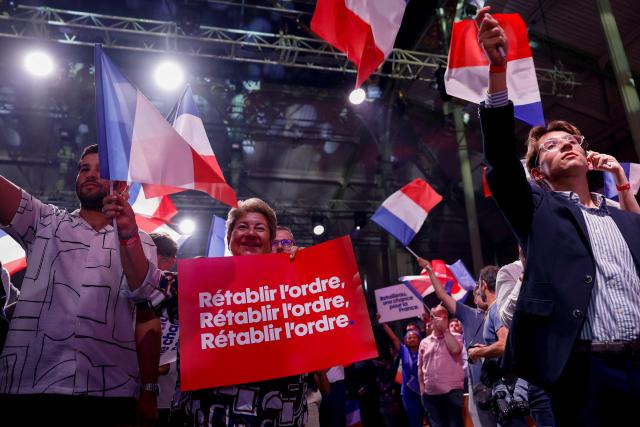 A supporter holds a placard reading "Restablish order, Restablish order, Restablish order." as President of French right-wing party Les Republicains (LR) and candidate for France’s 2027 presidential election Bruno Retailleau arrives to deliver a speech during a meeting in Nogent-sur-Marne, east of Paris, on September 12, 2026. (Photo by Ian LANGSDON / AFP)