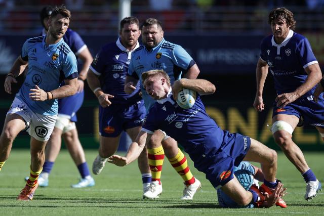 Castres' New Zealand centre Jack Goodhue (C) is tackled during the French Top14 rugby union match between USA Perpignan and Castres Oympique at the Aime-Giral stadium in Perpignan, south-western France on September 12, 2026. (Photo by Valentine CHAPUIS / AFP)