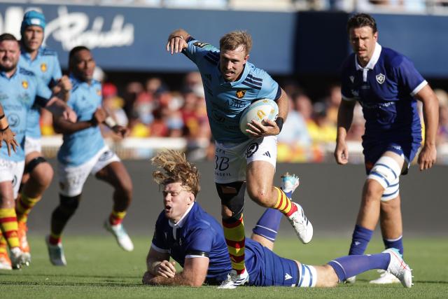 Perpignan's New Zealand centre Braydon Ennor (CR) skips out of a tackle as he runs with the ball during the French Top14 rugby union match between USA Perpignan and Castres Oympique at the Aime-Giral stadium in Perpignan, south-western France on September 12, 2026. (Photo by Valentine CHAPUIS / AFP)