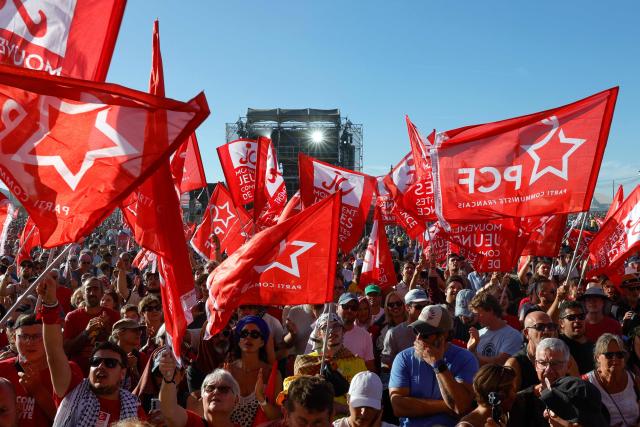 Supporters wave flags as they attend a speech by the French Communist Party (PCF) leader and candidate in France's 2027 presidential election during the annual "Fete de l'Humanite" festival organised by French left wing newspaper L'Humanite, in Le Plessis-Pate, south of Paris, on September 12, 2026. (Photo by GEOFFROY VAN DER HASSELT / AFP)