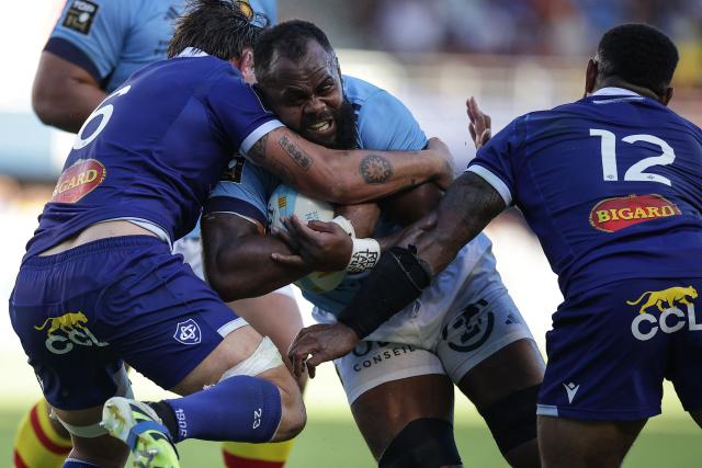 Perpignan's Fijian lock Peceli Yato (C) is tackled by Castres' French flanker Baptiste Delaporte (L) during the French Top14 rugby union match between USA Perpignan and Castres Oympique at the Aime-Giral stadium in Perpignan, south-western France on September 12, 2026. (Photo by Valentine CHAPUIS / AFP)