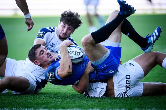 Vannes' French full-back Anthony Bouthier (C) fights for the ball with Montpellier's French wing Dimitri Delibes (L) during the French Top14 rugby union match between Rugby Club Vannetais (RCV, Vannes) and Montpellier Herault Rugby (MHR) at the Rabine Stadium in Vannes, western France, on September 12, 2026.  (Photo by Loic VENANCE / AFP)