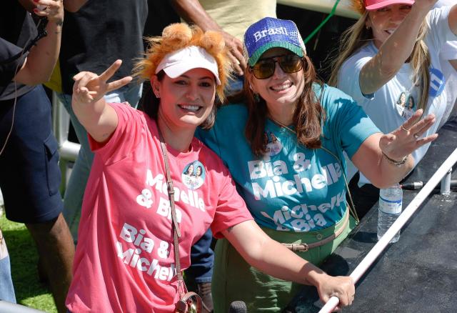 Brazil's former First Lady and candidate for the Federal Senate for the Liberal Party (PL), Michelle Bolsonaro and also senate candidate Bia Kicis gesture during a motorcade in Ceilandia, an administrative region of Brasilia's Federal District, on September 12, 2026. Michelle Bolsonaro backs her stepson, Flavio Bolsonaro, for the upcoming October 4 presidential election. (Photo by Sergio Lima / AFP)