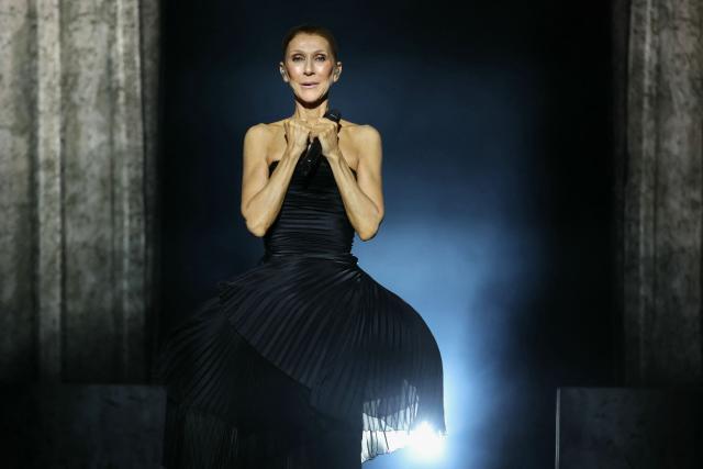 Canadian singer Celine Dion acknowledges the audience as she appears on stage at the start of her first concert of a series at the Plenitude Arena in Nanterre, west of Paris on september 12, 2026. Celine Dion is to fulfil her dream of returning to the stage after years battling a rare neurological disorder, with thousands of fans from all over the world descending on the arena west of Paris. (Photo by Thomas SAMSON / AFP)