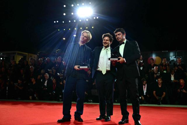 Director Tommaso Landucci and Damiano Femfert winners of the Orizzonti Award for Best Screenplay for "I figli della scimmia" (The children of the monkey), and Italian actor Riccardo Scamarcio, winner of the Orizzonti Award for Best Actor attend a photocall on the red carpet following the closing ceremony of the 83rd Venice Film Festival at Venice Lido on September 12, 2026 (Photo by Stefano RELLANDINI / AFP)