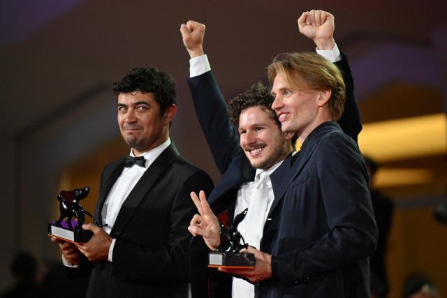 Director Tommaso Landucci and Damiano Femfert winners of the Orizzonti Award for Best Screenplay for "I figli della scimmia" (The children of the monkey), and Italian actor Riccardo Scamarcio, winner of the Orizzonti Award for Best Actor attend a photocall on the red carpet following the closing ceremony of the 83rd Venice Film Festival at Venice Lido on September 12, 2026 (Photo by Tiziana FABI / AFP)