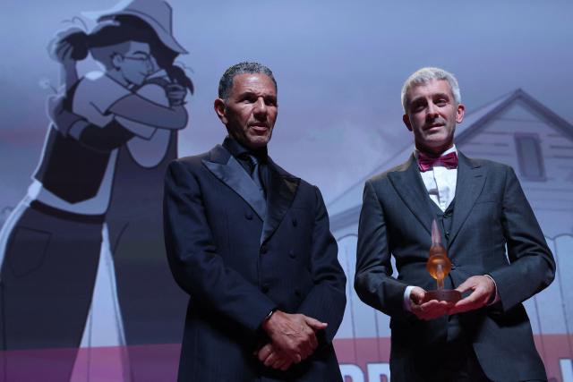 US producer Ross Murray (R) poses near jury president French actor and producer Rochdy Zem after receiving the critics' award and the jury prize for the adult animation drama movie "Tangles" during the 52nd edition of the Deauville American film festival, in Deauville, northwestern France on September 11, 2026. (Photo by Alain JOCARD / AFP)