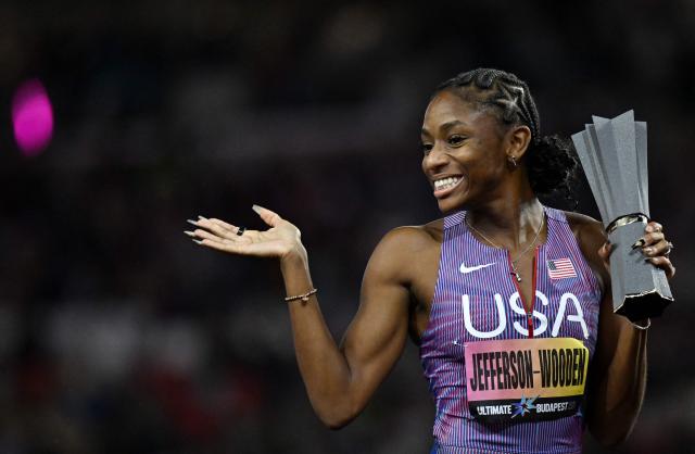 US' Melissa Jefferson-Wooden celebrates her victory with her trophy in the women's 100m final during the World Athletics Ultimate Championship at the Gyula Zsivotzky National Athletics Centre, in Budapest on September 12, 2026. (Photo by Jewel SAMAD / AFP)