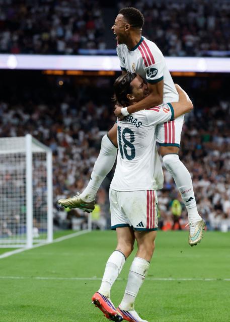 Real Madrid's Spanish defender #18 Alvaro Fernandez Carreras  (L) celebrates with Real Madrid's French forward #10 Kylian Mbappe after scoring his team's second goal during the Spanish league football match between Real Madrid CF and Rayo Vallecano de Madrid at Santiago Bernabeu Stadium in Madrid on September 12, 2026. (Photo by Oscar DEL POZO / AFP)