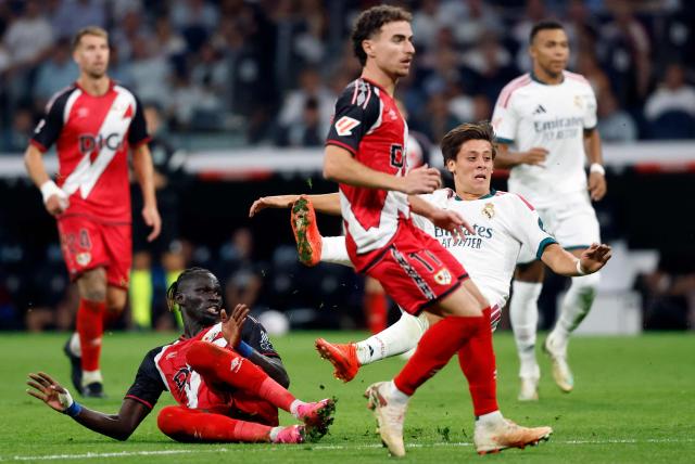 Real Madrid's Turkish midfielder #15 Arda Guler (R) attempts to score ext to Rayo Vallecano's Senegalese midfielder #06 Pathe Ciss (L) during the Spanish league football match between Real Madrid CF and Rayo Vallecano de Madrid at Santiago Bernabeu Stadium in Madrid on September 12, 2026. (Photo by Oscar DEL POZO / AFP)