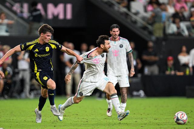 Inter Miami's Argentine forward #10 Lionel Messi is grabbed by his jersey by Nashville's US midfielder #16 Matthew Corcoran (L) during a Major League Soccer (MLS) regular season football match between Inter Miami CF and Nashville FC at Nu Stadium in Miami, Florida, on September 12, 2026. (Photo by CHANDAN KHANNA / AFP)